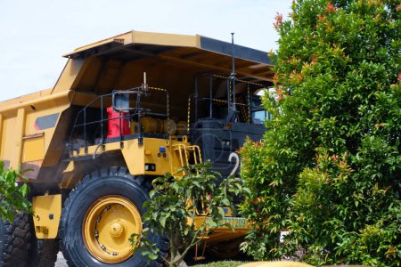Foto de Gran camión minero amarillo detrás de los árboles - Imagen libre de derechos