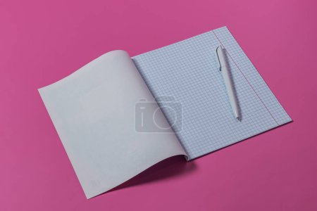 Foto de Cuaderno de estudio con bolígrafo blanco aislado sobre fondo rosa. Concepto de educación o preparación escolar - Imagen libre de derechos