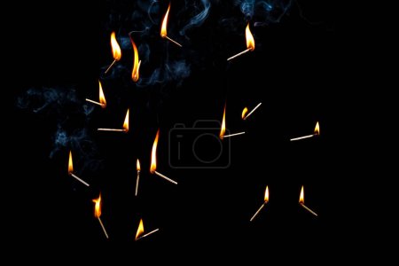 Téléchargez les photos : Allumettes brûlantes sur un fond noir - en image libre de droit