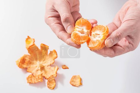 Photo for Peel and split ripe tangerine isolated on white background. Non-GMO natural vitamin concept - Royalty Free Image