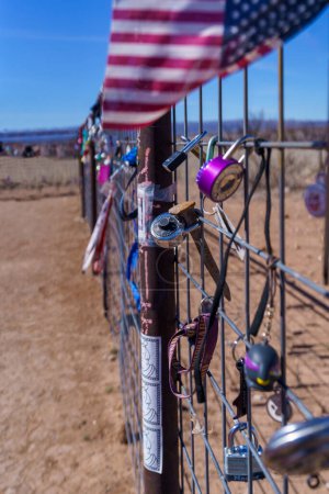 Photo for Collection of padlocks and an American flag on a wire metal fence in the desert of West Texas - Royalty Free Image