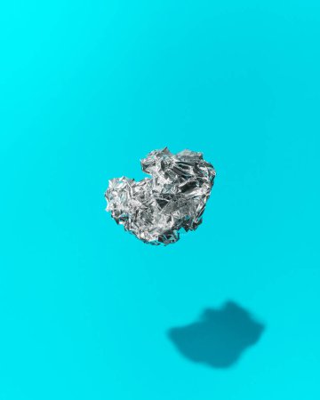 Photo for Ball of Crumpled Aluminum Foil Floating on a Blue Background Concept Image - Royalty Free Image