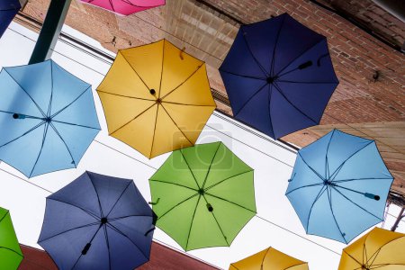 Photo for Looking up at colorful umbrellas and red brick walls in downtown Redlands, California - Royalty Free Image