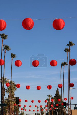 Photo for Rows of red paper lanterns hanging with palm trees during the Chinese New Year Lunar Festival - Royalty Free Image
