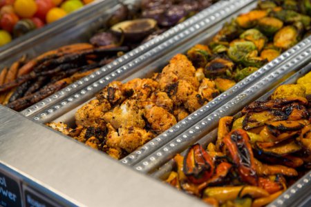 Photo for Roasted and spicy Cauliflower Sambal in a silver container with other grilled vegetables at a Food Bar. - Royalty Free Image
