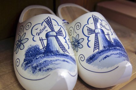 Photo for Holland Dutch Wooden Clogs Klompen. White with delft blue painting of windmill scene on shoes. - Royalty Free Image