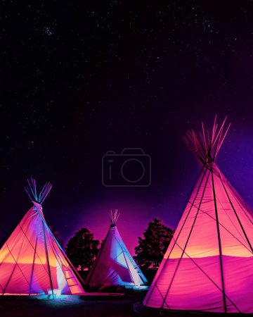 Photo for Three vaporwave-style teepees glowing at night under stars in Marfa, Texas - Royalty Free Image