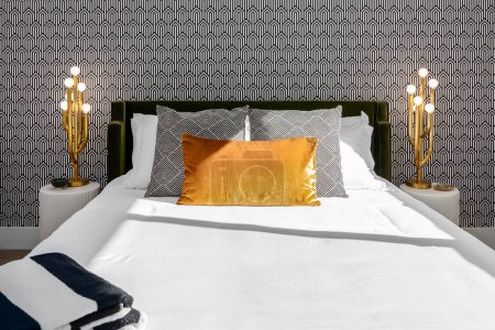 Photo for Luxurious black and white bedroom with gold lamps, gold pillow, and cool wallpaper - Royalty Free Image