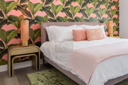 Photo for Bedroom with pink and green accent colors and tropical wallpaper theme - Royalty Free Image