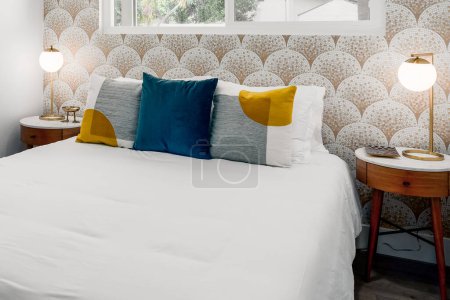Photo for Modern guest bedroom with comfortable bed, pillows, night stands, and scale mosaic tile wallpaper - Royalty Free Image