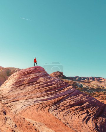 Photo for Man standing on the top of a rock at the Fire Wave in Valley of Fire State Park, Nevada - Royalty Free Image