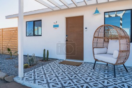 Photo for Modern bohemian desert home front porch with tile and rattan chair in the daytime - Royalty Free Image