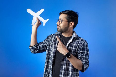 Photo for Travel destination, journey, airport. A man holding paper airplane and pointing with fingers. - Royalty Free Image