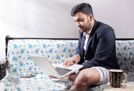 Photo for Work from home concept, man wearing half formal suit using laptop on sofa - Royalty Free Image