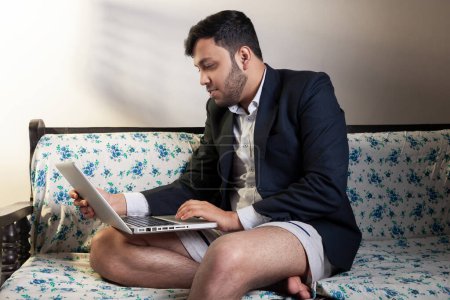 Photo for Adult guy using laptop for office work at home sitting on couch - Royalty Free Image