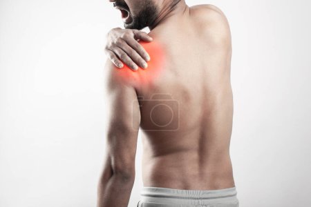 Photo for Body pain, shoulder soreness, joint injury. Asian fitness guy inflamed with shoulder joint zone Highlighted in red glow. - Royalty Free Image