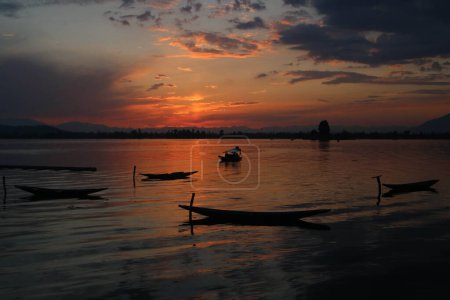 Photo for June 16,2023, Srinagar Kashmir, India :  A man steers his boat in Dal Lake during sunset in Srinagar - Royalty Free Image