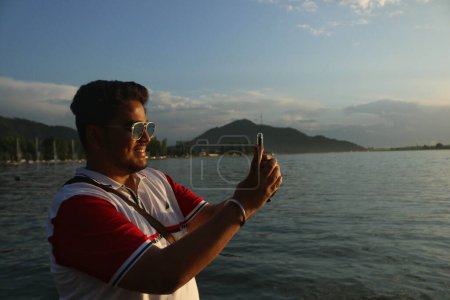 Téléchargez les photos : 16 juin 2023, Srinagar Cachemire, Inde : Un touriste indien prend une photo de son téléphone pendant une journée ensoleillée à Srinagar - en image libre de droit