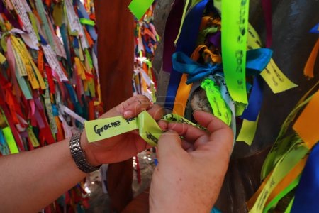 Photo for May 24, 2023 in Cancun, Mexico: Faithful place the ribbons with thanks for Mary Undoer of Knots in the sanctuary located in the jungle of Cancun, the only church of its kind in Mexico and in the world - Royalty Free Image