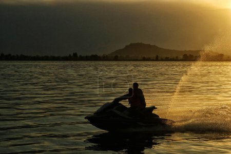 Photo for June 16,2023, Srinagar Kashmir, India : An Indian tourist enjoy a Jet- Ski ride on the waters of dal lake during sunset in Srinagar - Royalty Free Image