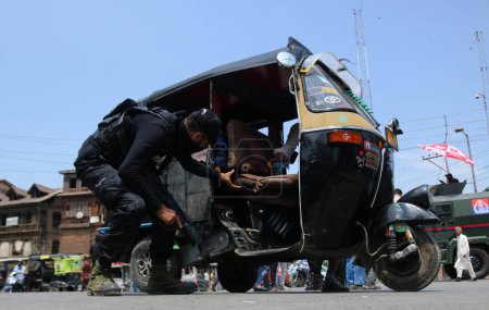 Téléchargez les photos : 14 août 2023, Srinagar Cachemire, Inde : Un soldat du Groupe d'Opération Spéciale Indien (SOG) vérifie un pousse-pousse automobile lors d'une opération de recherche à Srinagar, avant le 77e Jour de l'Indépendance du pays - en image libre de droit