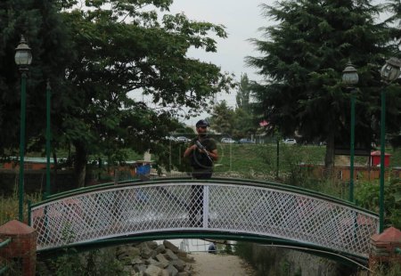 Photo for August 14,2023, Srinagar Kashmir, India : An Indian Special Operation Group (SOG) trooper walks over a bridge during a search operation in Srinagar, ahead of the country's 77th Independence Day - Royalty Free Image