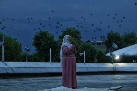 Téléchargez les photos : 16 juillet 2023, Srinagar Cachemire, Inde : Une femme musulmane du Cachemire prie en attendant que le prêtre en chef montre une relique que l'on croit être un cheveu de la barbe du prophète Mohammad (PBUH) lors de prières spéciales - en image libre de droit