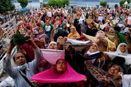 Foto de 07 de julio 2023, Srinagar Cachemira, India: Las mujeres musulmanas levantan la mano mientras oran al ver una reliquia del Profeta Muhammad durante las oraciones especiales en el aniversario de la muerte de Hazrat Usman Ghani, el tercer califa del Islam, en el santuario Hazratbal - Imagen libre de derechos
