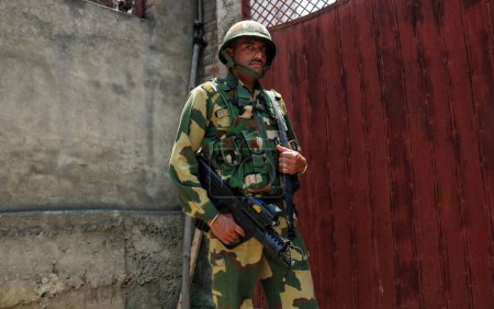Foto de 12 de julio de 2023, Srinagar Cachemira, India: Un soldado paramilitar indio hace guardia mientras altos dirigentes del partido y prominentes trabajadores del Comité del Congreso de Jammu y Cachemira Pradesh (JKPCC) organizan una protesta silenciosa (Maun Satyagaraha) - Imagen libre de derechos