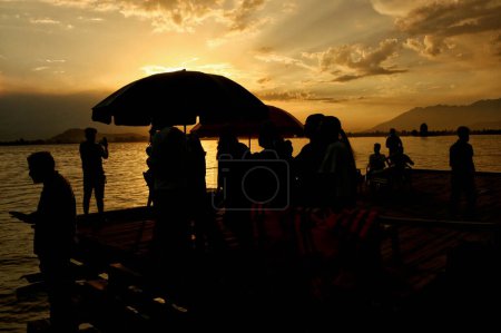 Photo for June 16,2023, Srinagar Kashmir, India : Indian tourists enjoy Sunset view on the banks of dal lake in Srinagar. On June 16,2023 in Srinagar Kashmir, India - Royalty Free Image