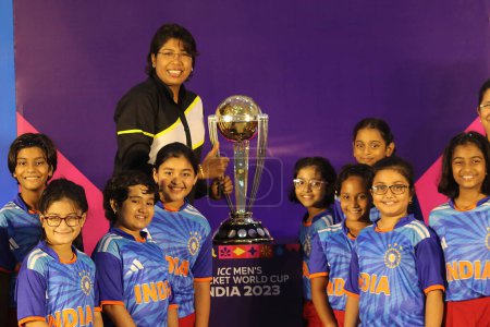 Téléchargez les photos : 06 juillet 2023, Kolkata, Inde : Des élèves avec l'ancienne joueuse de cricket indienne Jhulan Goswami applaudissent à côté du trophée de la Coupe du monde internationale de cricket ICC Mens du Conseil international de cricket, lors d'une visite du trophée dans une école - en image libre de droit