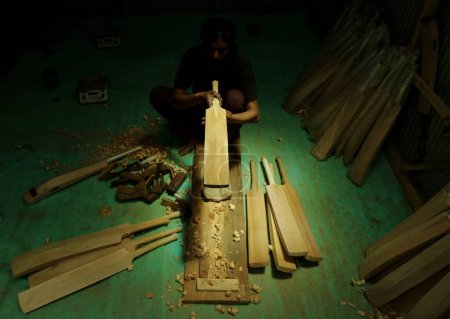 Photo for June 12,2023, Srinagar Kashmir, India : A labourer works in a GR8 cricket bat manufacturing unit in Sangam, some 38 kilometers south of Srinagar - Royalty Free Image