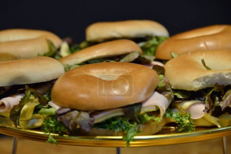 Foto de Vista general de un sándwich hecho con pan de Bagel jamón de pavo, lechuga y adornado con un tomate - Imagen libre de derechos