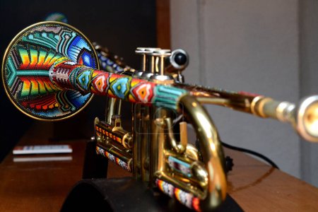 Foto de Una trompeta decorada con diseños y ornamentos hechos de cuentas multicolores hechas por artesanos indígenas de las comunidades Huichol de los estados Jalisco y Nayarit de la cultura Wixarika - Imagen libre de derechos