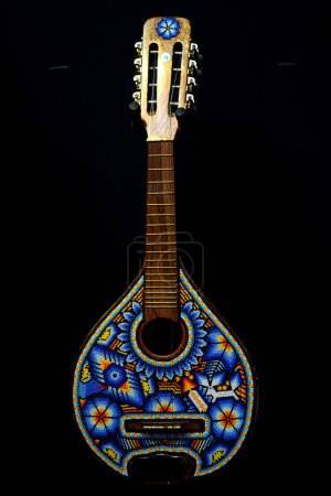 Foto de Una guitarra decorada con diseños y ornamentos hechos de cuentas multicolores hechas por artesanos indígenas de las comunidades Huichol de los estados Jalisco y Nayarit de la Cultura Wixarika / Eyepix Group - Imagen libre de derechos