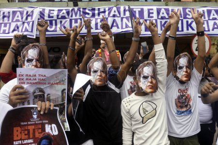 Téléchargez les photos : 7 septembre 2023, Kolkata, Inde : Les fans de l'acteur Shah Rukh Khan tiennent un rassemblement dans son soutien portant des masques en carton du personnage Raj Vardhan Thakur joué par Shah Rukh Khan dans le film "Jawan" devant le cinéma où le film est projeté - en image libre de droit