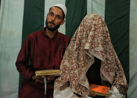 Téléchargez les photos : Srinagar, Cachemire, Inde - 10 septembre 2023 : Un couple nouvellement marié pose pour la photographie lors d'un mariage de masse à Srinagar. Mariages de masse en Inde organisés par les organisations sociales principalement pour aider les familles économiquement arriérées qui ne peuvent pas - en image libre de droit
