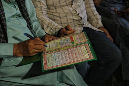 Téléchargez les photos : Srinagar, Cachemire, Inde - 10 septembre 2023 : Un religieux musulman remplit le contrat de mariage islamique (Nikkah Naama) lors d'un mariage de masse à Srinagar - en image libre de droit