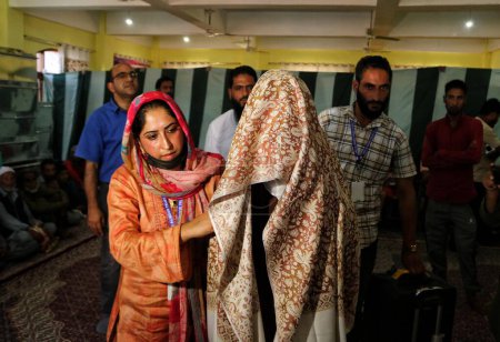 Téléchargez les photos : Srinagar, Cachemire, Inde - 10 septembre 2023 : Une musulmane du Cachemire en robe de mariée arrive pour un mariage de masse à Srinagar. Les mariages de masse en Inde sont organisés par des organisations sociales principalement pour aider les familles économiquement arriérées - en image libre de droit