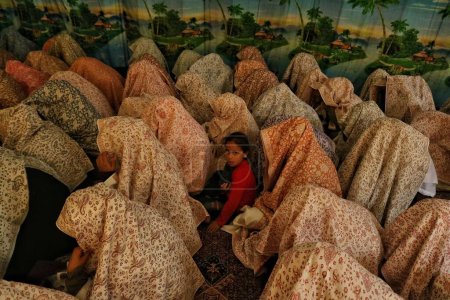 Téléchargez les photos : Srinagar, Cachemire, Inde - 10 septembre 2023 : Une jeune fille siège parmi les épouses musulmanes du Cachemire lors d'un mariage de masse à Srinagar. Mariages de masse en Inde organisés par des organisations sociales pour aider les familles économiquement arriérées - en image libre de droit