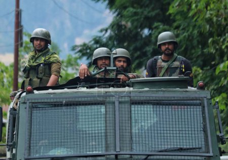 Téléchargez les photos : 16 septembre 2023, Srinagar Cachemire, Inde : Des soldats de l'armée indienne sont vus près du site de la bataille des armes à feu qui est entré le quatrième jour dans le village Gadole de Kokernag dans le district d'Anantnag - en image libre de droit