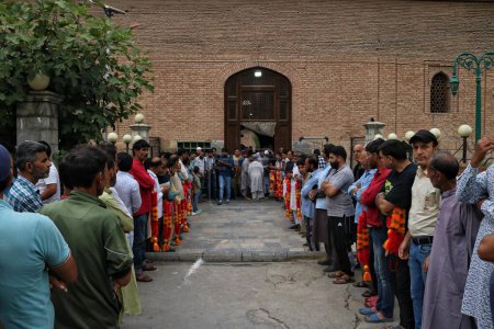 Téléchargez les photos : 22 septembre 2023, Srinagar Cachemire, Inde : Les gens attendent avec des guirlandes que le leader séparatiste Mirwaiz Umar Farooq arrive pour prononcer le sermon du vendredi après quatre ans d'assignation à résidence à la Grande Mosquée (Jamia Masjid) dans la vieille ville de Srinagar - en image libre de droit