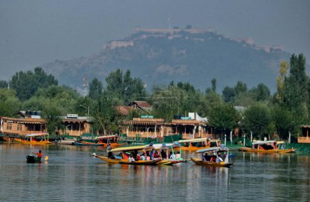 Téléchargez les photos : Srinagar Cachemire, Inde - 27 septembre 2023 : Les touristes profitent d'une promenade en bateau sur les eaux du lac Dal à l'occasion de la Journée mondiale du tourisme à Srinagar. Le tourisme est l'un des piliers de l'économie du Cachemire avec l'agriculture - en image libre de droit