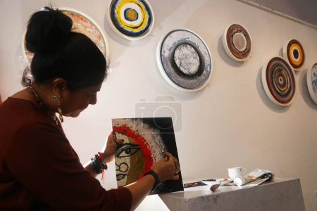 Téléchargez les photos : Kolkata City, Inde - 30 septembre 2023 : Peintre de renom Shubhra Chand touches finales à une peinture à l'huile utilisent l'or des dieux hindous Durga à son exposition de peinture solo à l'Académie des Beaux-Arts - en image libre de droit