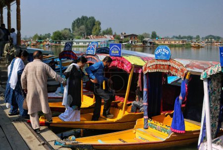 Téléchargez les photos : Srinagar Cachemire, Inde - 27 septembre 2023 : Les touristes entrent dans une glisse de Shikara avant de faire un tour sur les eaux du lac Dal pendant la Journée mondiale du tourisme à Srinagar - en image libre de droit