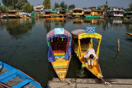 Téléchargez les photos : Srinagar Cachemire, Inde - 27 septembre 2023 : Un homme du Cachemire nettoie son bateau sur les eaux du lac Dal pendant la Journée mondiale du tourisme à Srinagar. Le tourisme est l'un des piliers de l'économie du Cachemire avec l'agriculture - en image libre de droit