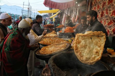 Téléchargez les photos : Srinagar Cachemire, Inde - 29 septembre 2023 : les gens achètent des collations locales auprès d'un vendeur à l'extérieur du sanctuaire Hazratbal à Srinagar - en image libre de droit