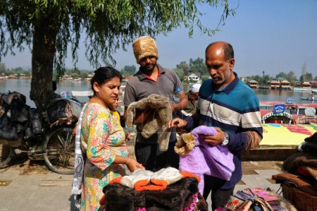 Téléchargez les photos : Srinagar Cachemire, Inde - 27 septembre 2023 : Un vendeur de rue vend un pull aux touristes sur les rives du lac Dal lors de la Journée mondiale du tourisme à Srinagar - en image libre de droit