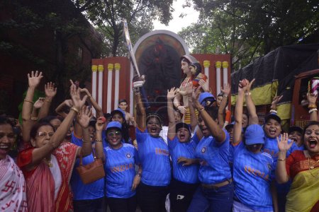 Téléchargez les photos : 8 octobre 2023, Kolkata, Inde : Le comité de puja de la communauté des membres porte le maillot de l "équipe indienne de cricket et encourage l" équipe pour la Coupe du monde de cricket masculin ICC 2023 lors d'une procession de l'idole de la déesse Durga - en image libre de droit