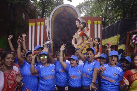Foto de 8 de octubre de 2023, Kolkata, India: El comité de puja de la comunidad de miembros usa jersy del equipo indio de cricket y anima al equipo para la Copa Mundial de Cricket Masculino ICC 2023 durante una procesión del ídolo de la Diosa Durga - Imagen libre de derechos